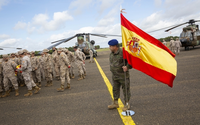 Un boina azul del BHELA I sostiene la bandera de España en la pista de la base de Almagro 