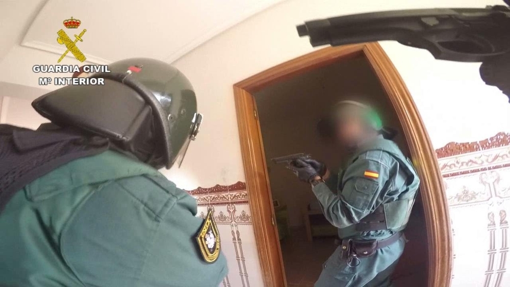 Agentes de la Guardia Civil accediendo a la vivienda con mandamiento judicial en busca de armas para evitar que se liaran a tiros los clanes enfrentados