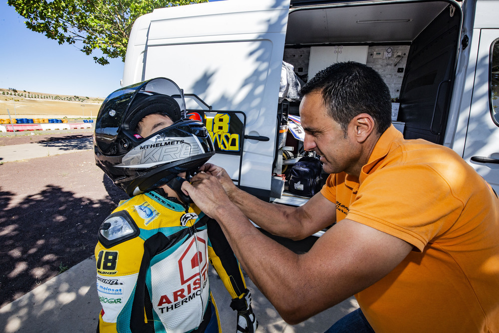 Tomás García, padre de Alonso, le ayuda a colocarse el casco.