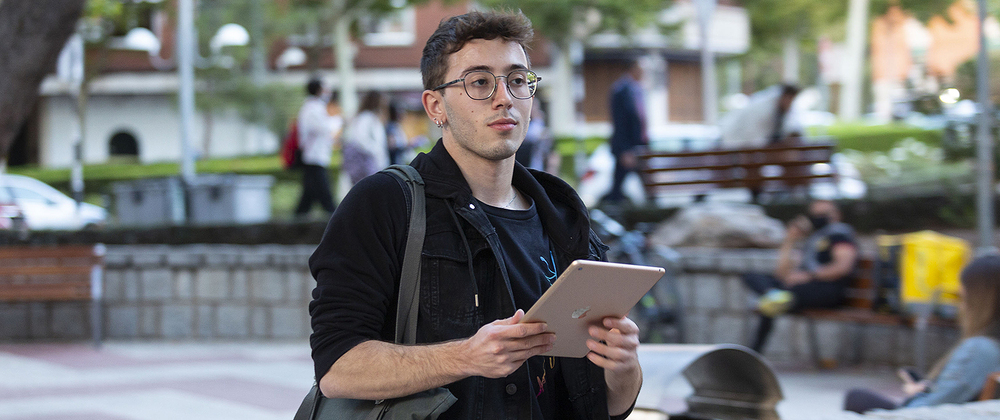 Nicolás, con una tablet y la bolsa con los libros, en uno de los recreos del grado superior que estudia en Ciudad Real.