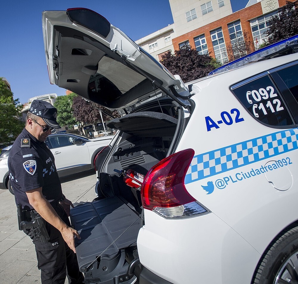 Un agente de la Policía Local revisa el maletero de su vehículo oficial  