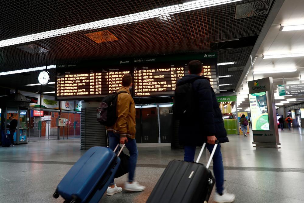 Dos viajeros en un vestíbulo en la estación de Atocha de Madrid.