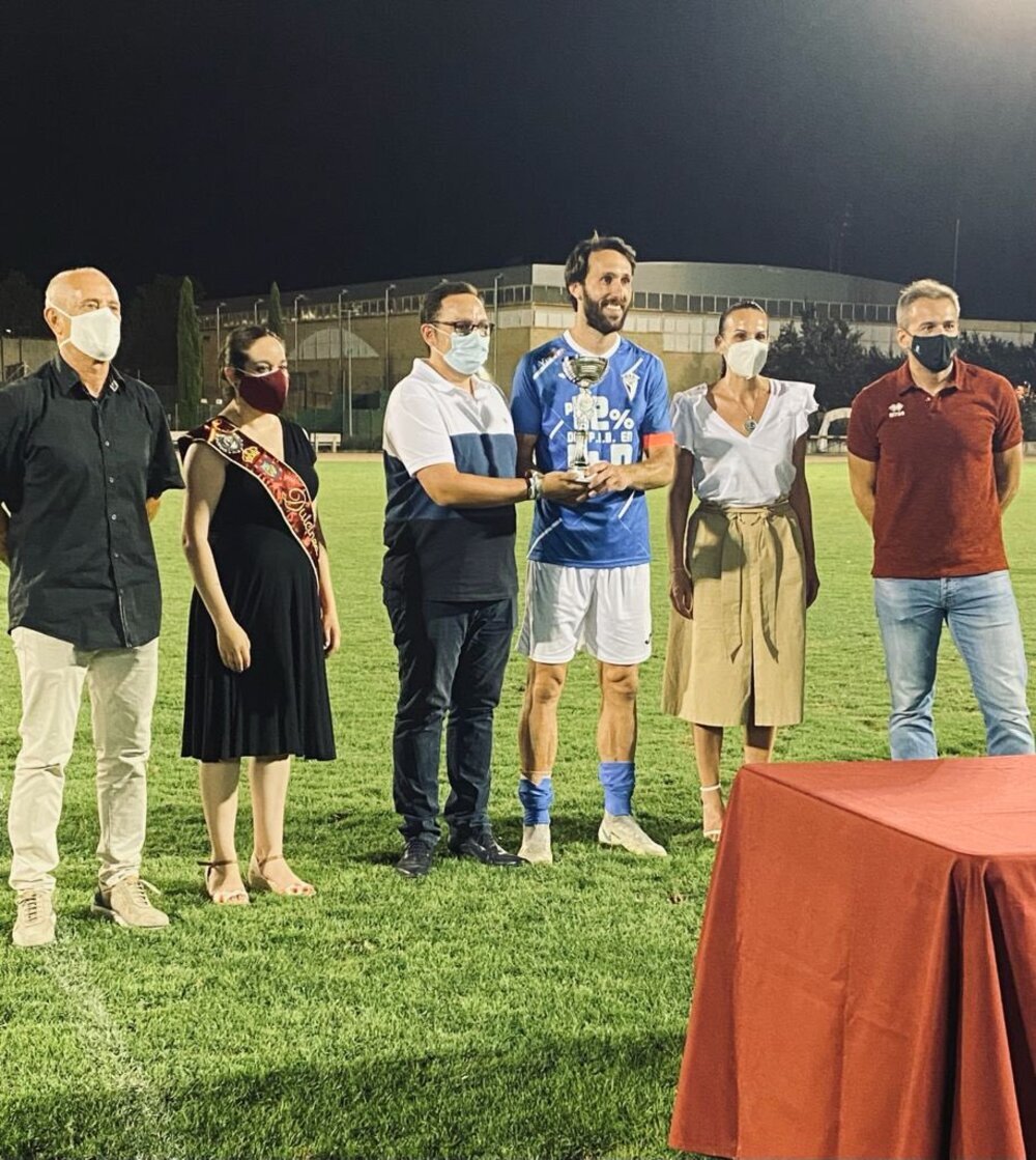 Rafa HGarcía, capitán el Manchego, recibe de Gonzalo Barrera, de la Asociación VivELA, el trofeo de campeón ante varias autoridades.