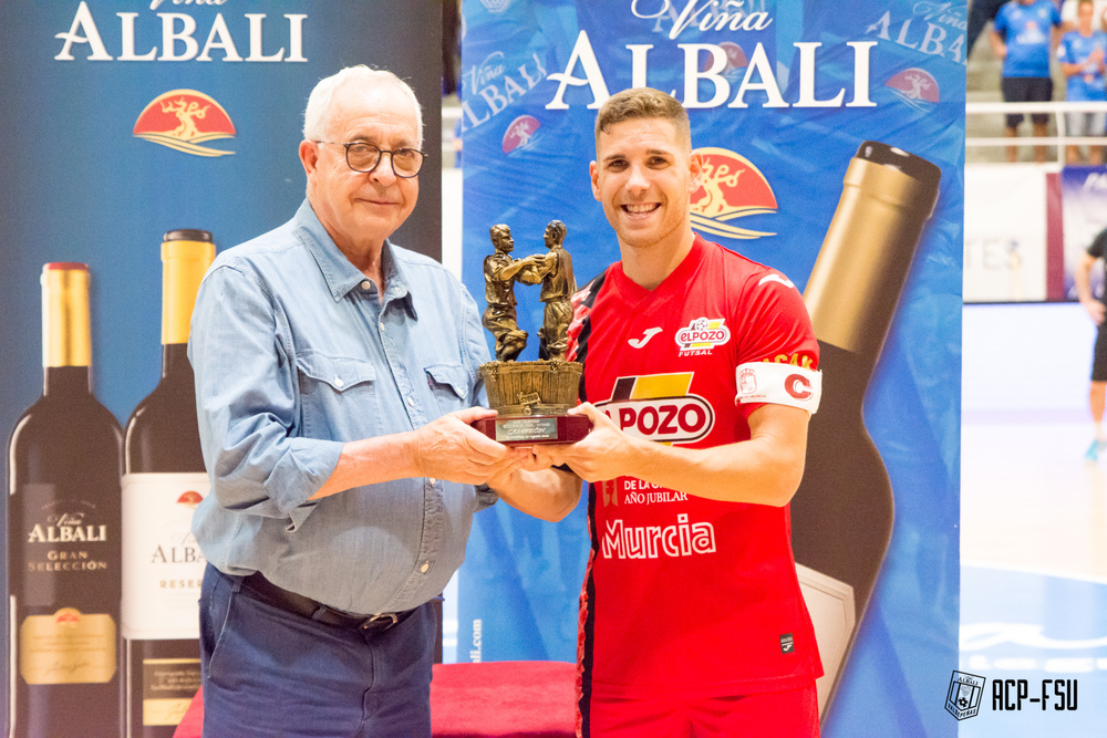 ElPozo recibe el trofeo de campeón de manos del patrocinador del equipo local.