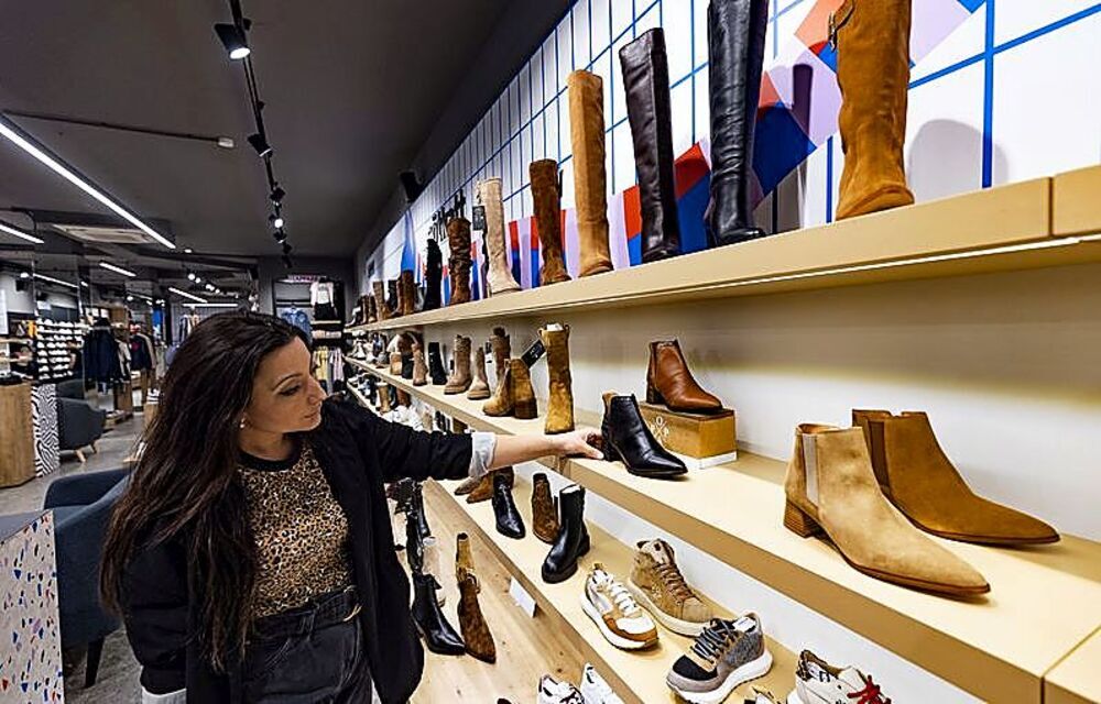 Una clienta mira el expositor de calzado de la tienda Sötkatt.