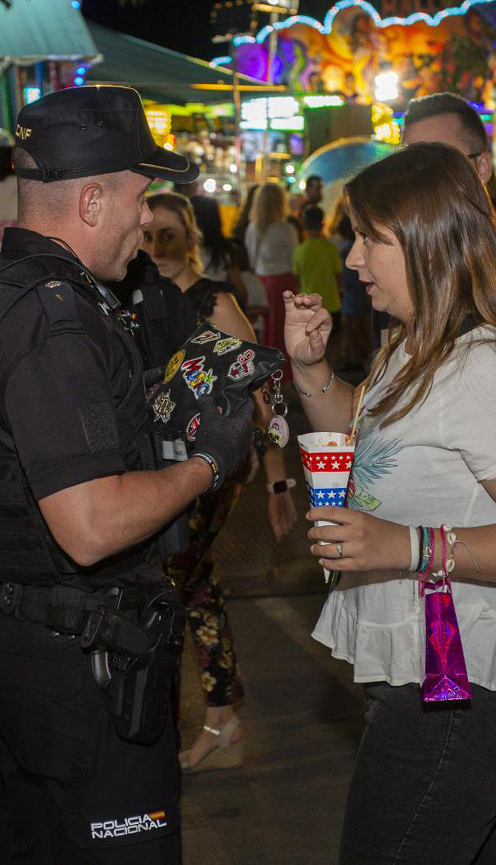 Momento en el que un policía nacional entrega a una joven el bolso sustraído y recuperado por un agente que no estaba de servicio