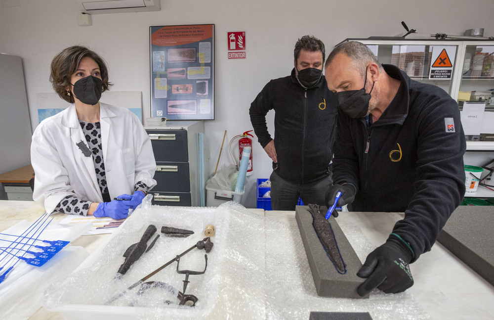Los operarios de la empresa de transporte, con la supervisión de Esther Arias, realizan el molde de espuma para embalar la espada.