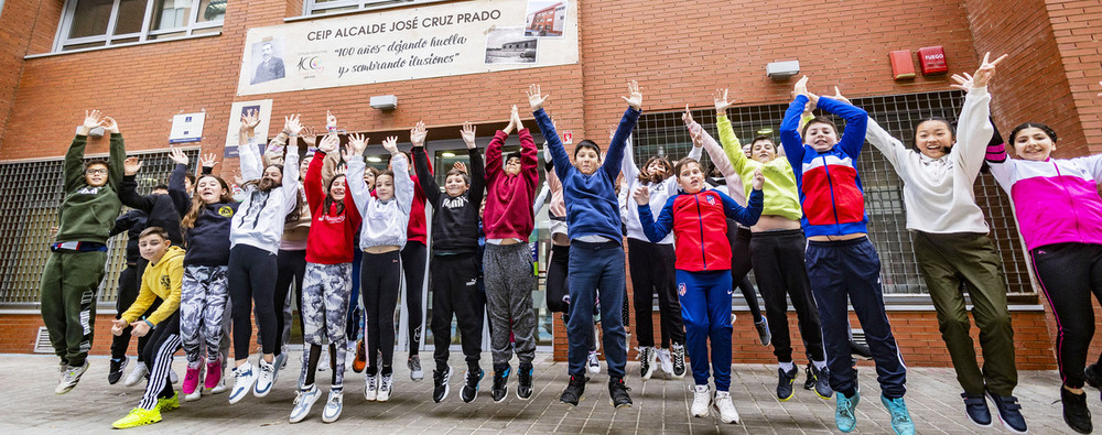 Estudiantes del colegio Cruz Prado celebran los 100 años de historia en la puerta del edificio, que anuncia su centenario con una pancarta.